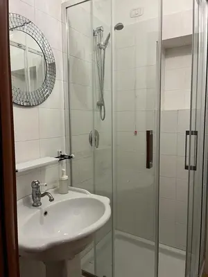 a white bathroom with a sink and a shower at CK Rooms in Rome