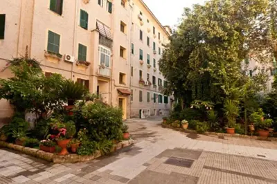 an empty street with potted plants and buildings at Lugiadra in Rome