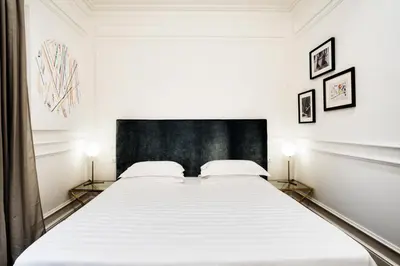 a bedroom with a large white bed with two lamps at The Shire Hotel in Rome