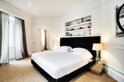 a white bedroom with a large bed with white sheets at The Shire Hotel in Rome