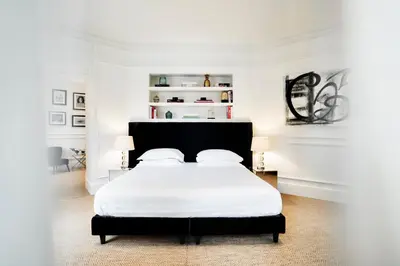 a white bedroom with a bed with white sheets and pillows at The Shire Hotel in Rome