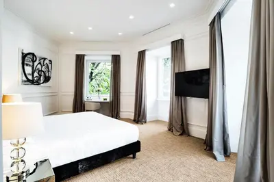 a bedroom with a white bed and windows at The Shire Hotel in Rome