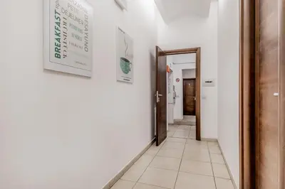 a corridor with white walls and a hallway with a door at Vatican City Guest House in Rome