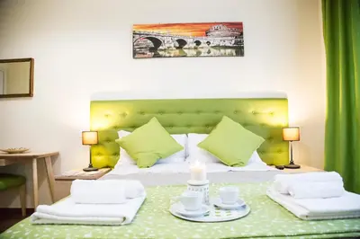 a bedroom with a bed with a green headboard at Vatican Suite 383 in Rome