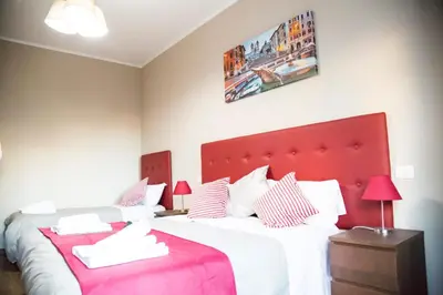 a bedroom with two beds and a red headboard at Vatican Suite 383 in Rome