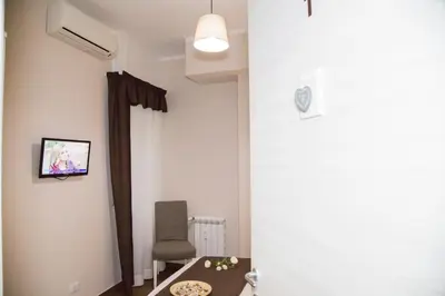 a room with a chair and a tv on the wall at Vatican Suite 383 in Rome