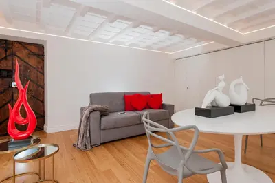 a living room with a couch and a table with red pillows at Hotel Navona in Rome