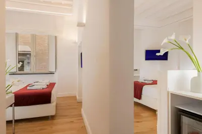 a white room with two beds and a window at Hotel Navona in Rome