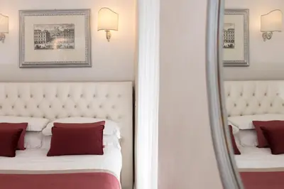 a bedroom with two beds with red pillows and a mirror at Hotel Navona in Rome