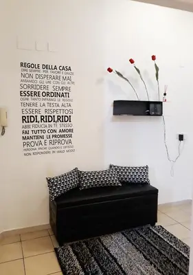 a black bench in a room with a vase on the wall at Il sole del Vaticano in Rome