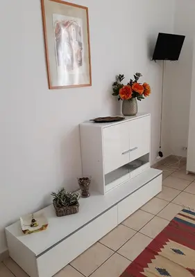 a white cabinet with a vase of flowers on it at Il sole del Vaticano in Rome