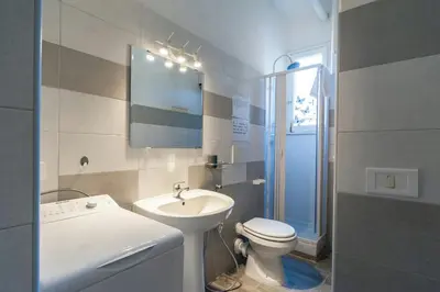 a white bathroom with a sink and a toilet at Il sole del Vaticano in Rome