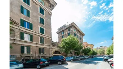 a city street with cars parked in front of buildings at Il sole del Vaticano in Rome