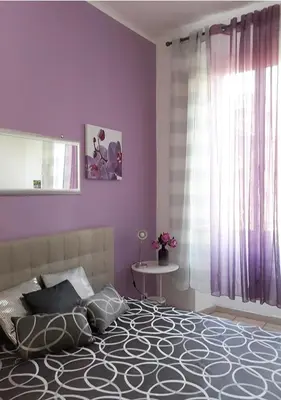 a bedroom with purple walls and a bed and a table at Il sole del Vaticano in Rome