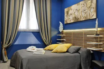 a blue bedroom with a bed with a stuffed animal on it at RHOMENJOY Suite Vatican in Rome