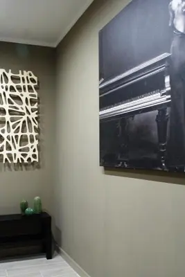 a living room with a piano and a picture on the wall at RHOMENJOY Suite Vatican in Rome