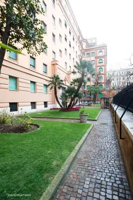 a walkway in a park next to a building at RHOMENJOY Suite Vatican in Rome