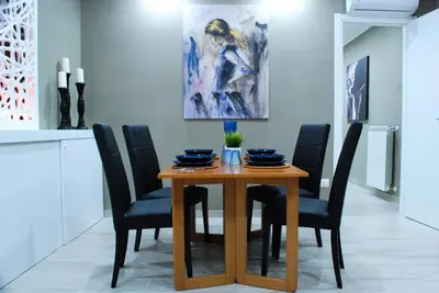 a dining room table with black chairs and a painting at RHOMENJOY Suite Vatican in Rome