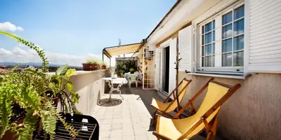 a patio with two chairs and a table on a balcony at Trastevere Station Terrace in Rome