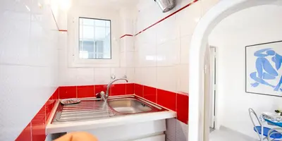 a kitchen with a sink and a red tile wall at Trastevere Station Terrace in Rome