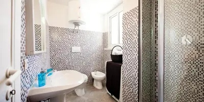a bathroom with a sink and a toilet and a shower at Trastevere Station Terrace in Rome