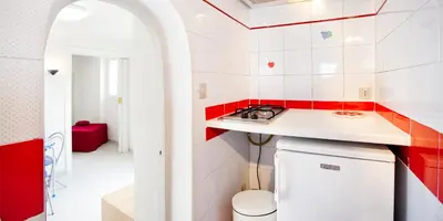 a kitchen with red and white tiled walls and a counter at Trastevere Station Terrace in Rome