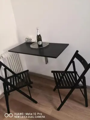 a black table with a bottle of wine and two chairs at Trastevere four seasons Glorioso in Rome