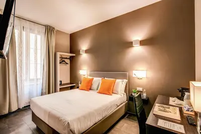 a bedroom with a bed with orange pillows and a desk at H501 Luxury Rooms in Rome