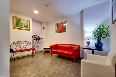 a living room with a red couch and chairs at Hotel Terminal in Rome