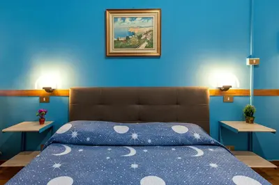 a blue bedroom with a bed with a blue wall at Alessandro A San Pietro Best Bed in Rome