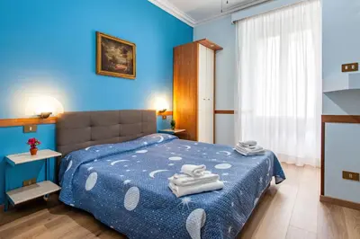 a blue bedroom with a bed with towels on it at Alessandro A San Pietro Best Bed in Rome
