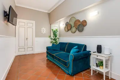 a living room with a blue couch and a tv at Pantheon Luxury House in Rome