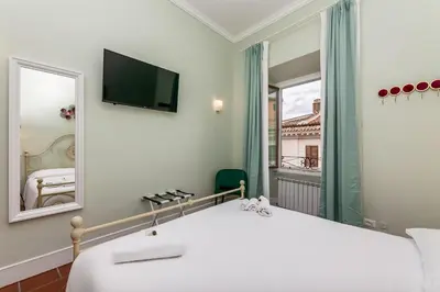 a bedroom with a large white bed and a mirror at Pantheon Luxury House in Rome