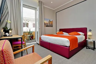 a hotel room with a large bed with an orange blanket at Relais Vittoria Colonna in Rome