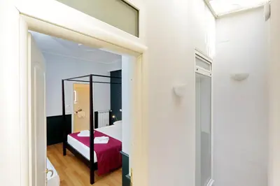 a bedroom with a red bed and a mirror at Relais Vittoria Colonna in Rome