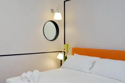 a bed with two white pillows and a mirror at Relais Vittoria Colonna in Rome