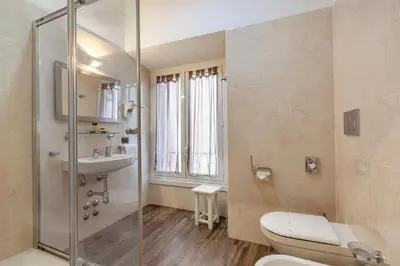 a bathroom with a shower and a toilet and a sink at Inn Rome Rooms & Suites in Rome