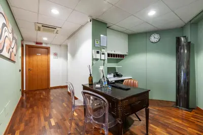 a room with a desk and chairs and a clock at Inn Rome Rooms & Suites in Rome