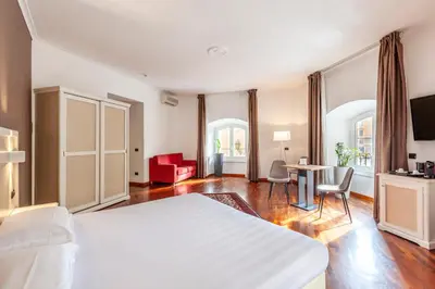 a bedroom with a white bed and a table and chairs at Inn Rome Rooms & Suites in Rome