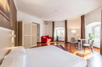 a bedroom with a white bed and a table and chairs at Inn Rome Rooms & Suites in Rome