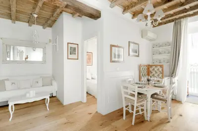 a white living room with a table and a bed at Paradise Suite Piazza Navona Campo de Fiori in Rome