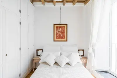 a white bedroom with a bed with white pillows at Paradise Suite Piazza Navona Campo de Fiori in Rome