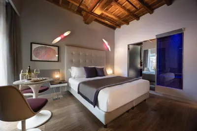 a bedroom with a large bed with a purple headboard at Maison Torre Argentina in Rome