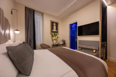 a hotel room with a bed and a living room at Maison Torre Argentina in Rome