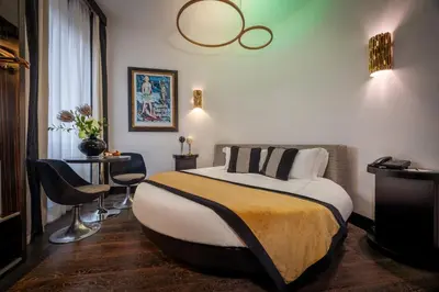 a bedroom with a bed and a chair and a television at Maison Torre Argentina in Rome