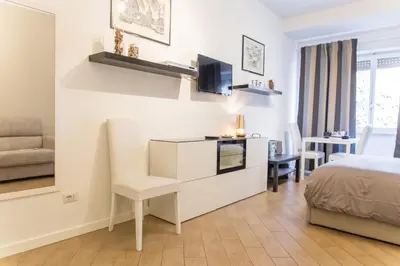 a bedroom with a bed and a desk with a television at Residenza Romana Vaticana in Rome