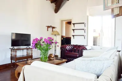 a living room with a couch and a table with flowers at Domus Rotundae Pantheon in Rome