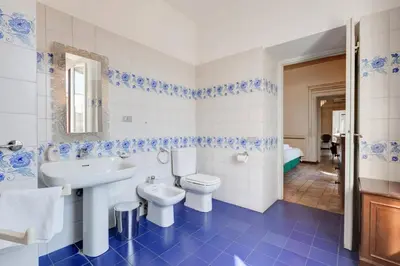 a blue and white bathroom with a sink and a toilet at Palazzo Giorgioli Apartment in Rome