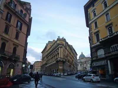a person walking down a city street with buildings at Palazzo Giorgioli Apartment in Rome