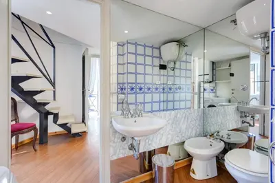 a bathroom with two sinks and a mirror at Palazzo Giorgioli Apartment in Rome